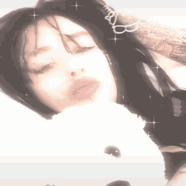 a girl is laying on a bed with a teddy bear in her lap .