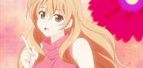a girl in a pink sweater is pointing up with her finger