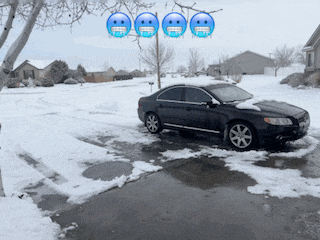 a black car is parked in a snow covered driveway