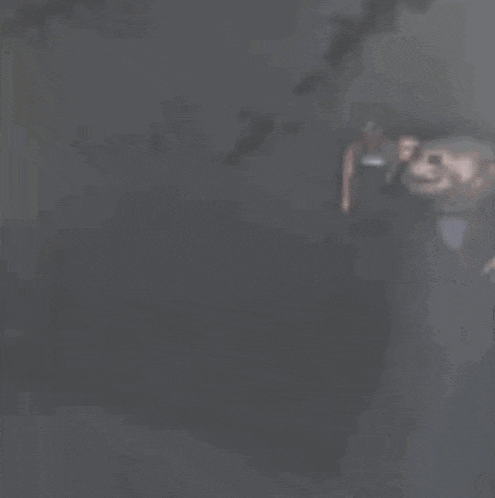 a man in a tuxedo is standing in the dark .