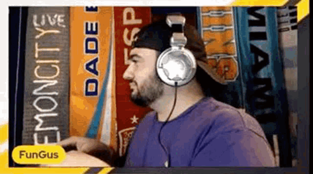 a man wearing headphones is sitting in front of a sign that says dade