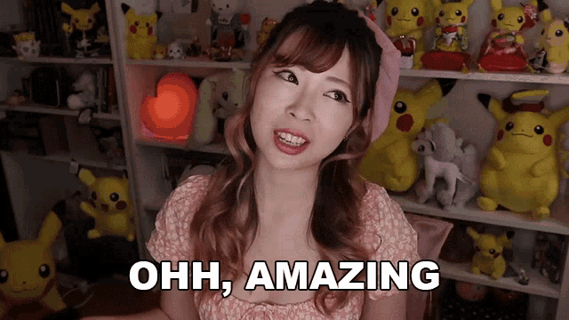 a woman says ohh amazing in front of a shelf full of stuffed pikachu