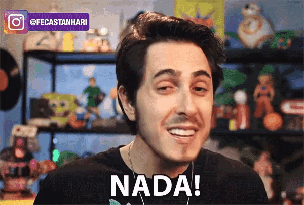 a man in a black shirt says nada in front of a shelf full of toys