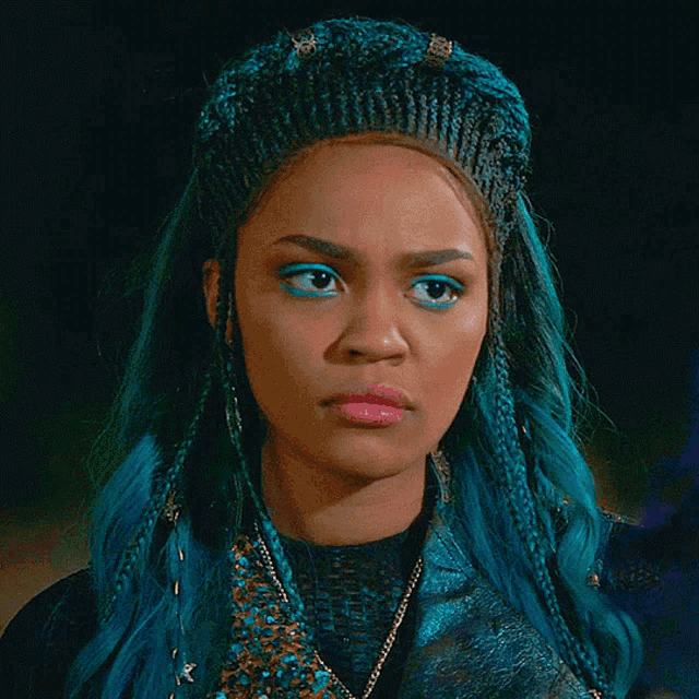 a woman with blue hair is wearing a knitted headband
