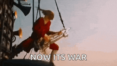 a man in a red shirt is playing a guitar and the words `` now its war '' are visible .