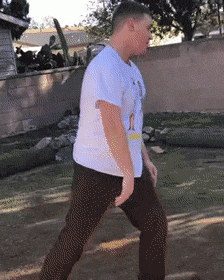 a man wearing a white shirt with a picture of a woman on it is walking