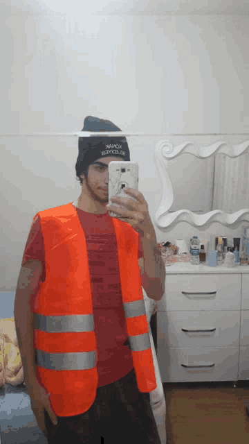 a man wearing an orange vest takes a picture of himself