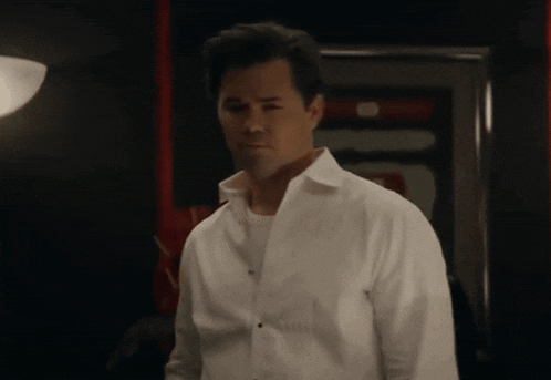 a man in a white shirt stands in front of a door