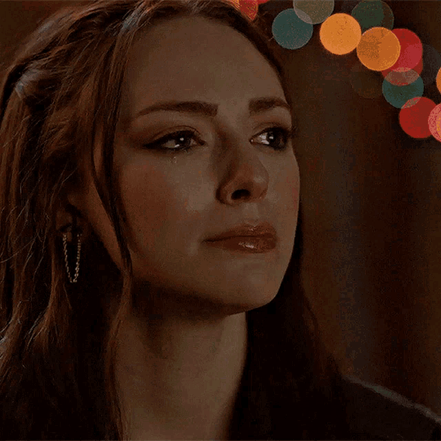 a close up of a woman 's face with a crying look on her face
