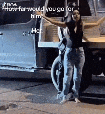 a woman is standing in front of a truck with her arms outstretched and a caption that says would you go for him .