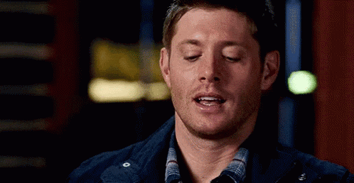 a man with his eyes closed is wearing a plaid shirt and a blue jacket .