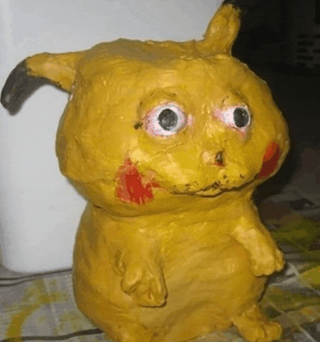 a statue of a yellow animal with big eyes and red spots on its face