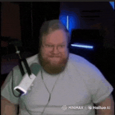 a man with a beard and glasses is sitting in front of a microphone ..