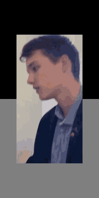 a close up of a man 's face with a black jacket on