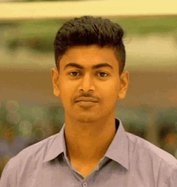 a young man with a beard and mustache is wearing a purple shirt .