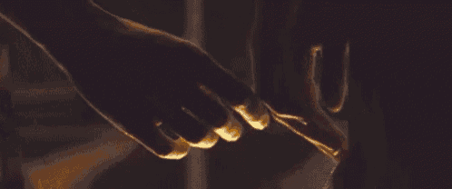 a close up of a couple holding hands in the dark .