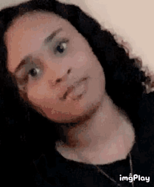 a young woman with long hair is looking at the camera .