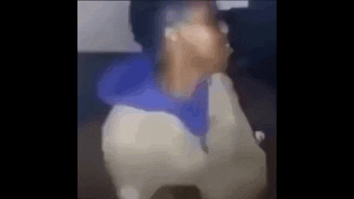 a blurry picture of a person wearing a blue hoodie and a white jacket .