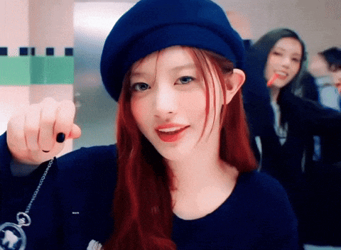 a woman with red hair wearing a blue hat and holding a pocket watch