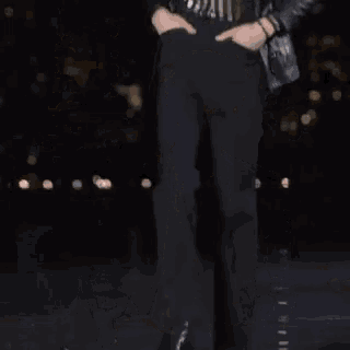 a person is walking on a stage in front of a crowd of people .