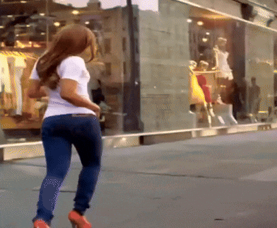 a woman in a white shirt and blue jeans stands in front of a store