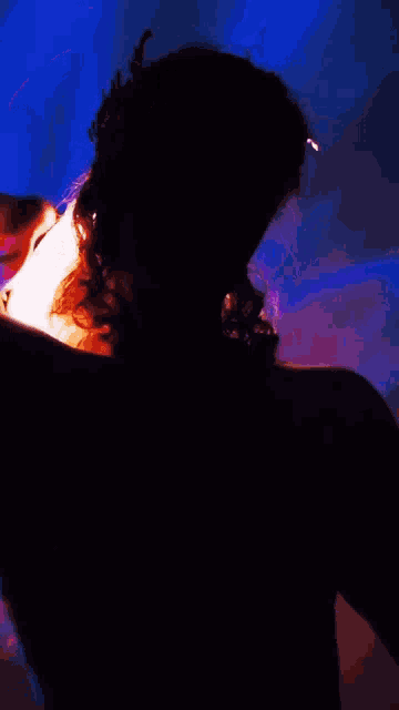 a silhouette of a shirtless man with a ring in his hair