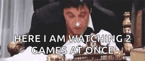 a man in a suit and top hat is sitting at a table with his eyes closed and watching two games at once .