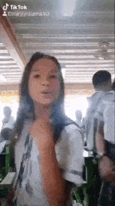 a girl in a school uniform is standing in a classroom with a group of people .