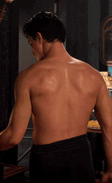 a shirtless man 's back is shown in a close up