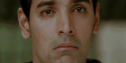 a close up of a man 's face with tears running down his eyes .