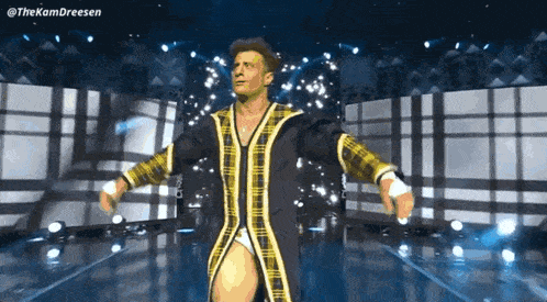 a man in a plaid robe is walking on stage