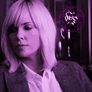a woman in a suit and white shirt with a purple circle that says dirty on it