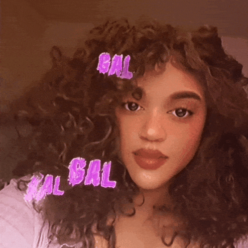 a girl with curly hair has the word bal written on her hair