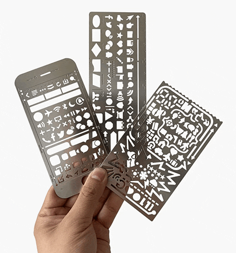 a person is holding three stencils in their hand one of which looks like a cell phone