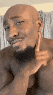 a shirtless bald man with a beard is making a funny face