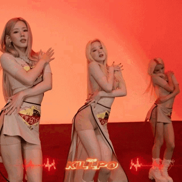 three women are dancing in front of a red background and the word killo is on the bottom right