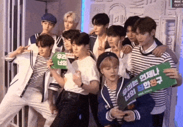 a group of young men are posing for a picture and one of them is holding a sign that says ' mbc '