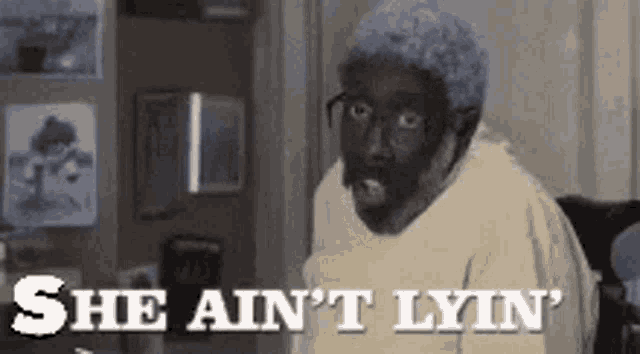 a man with glasses and a black face is sitting in a chair and says `` she ain 't lyn '' .