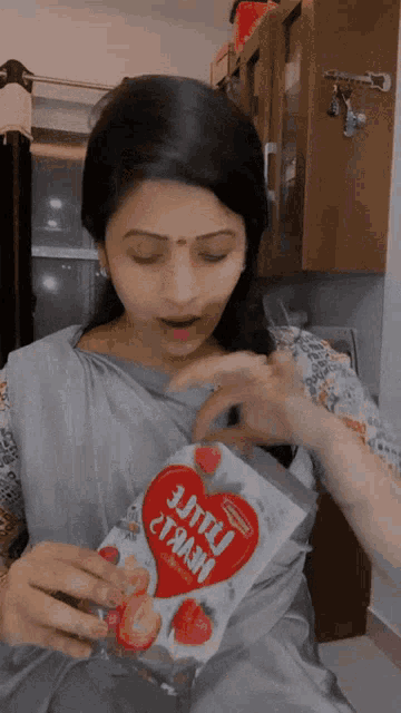 a woman is holding a bag that says little heart on it