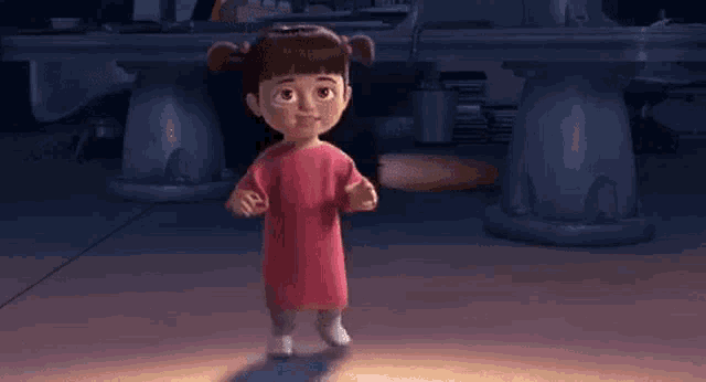 boo from monsters inc is standing in a dark room with a table in the background .