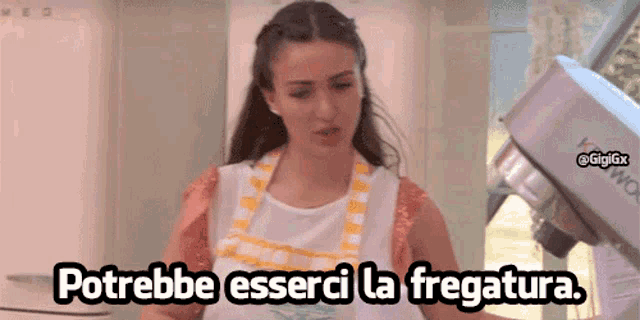 a woman in an apron stands in front of a kenwood mixer and says " potrebbe esserci la fregatura "