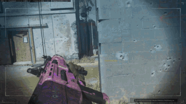a person holding a pink gun in front of a brick wall with bullet holes in it