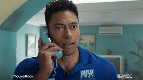 a man in a blue shirt with the word push on it is talking on a phone