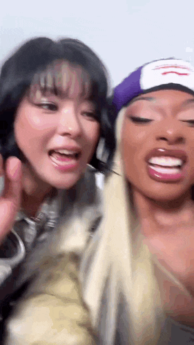 a couple of women are standing next to each other and smiling .