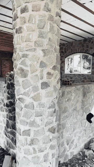 a large stone wall with a window in the middle