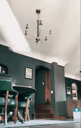 a living room with a chandelier hanging from the ceiling above a table