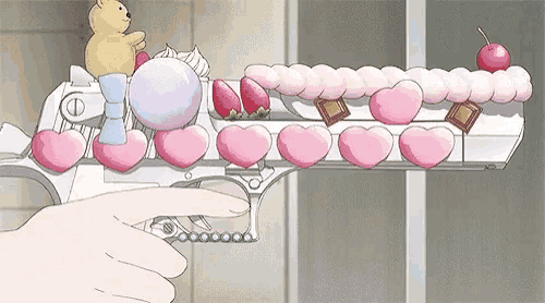 a person is pointing at a gun decorated with pink hearts .