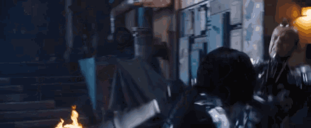 a close up of a person in a superhero costume fighting a monster in a dark room .