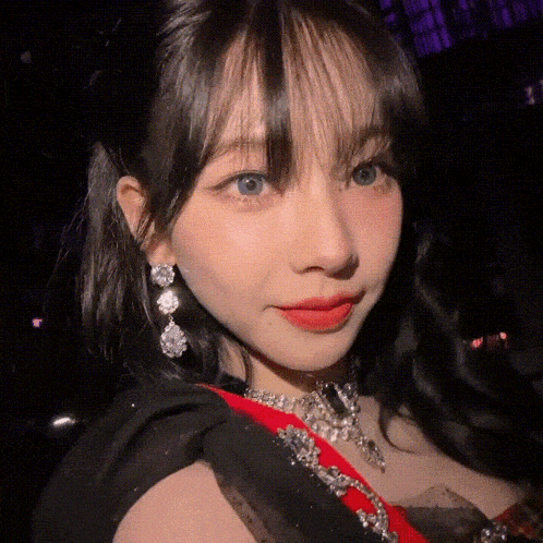 a close up of a woman wearing a necklace and earrings .
