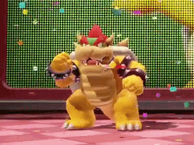 bowser is dancing in front of a screen with confetti falling from it .